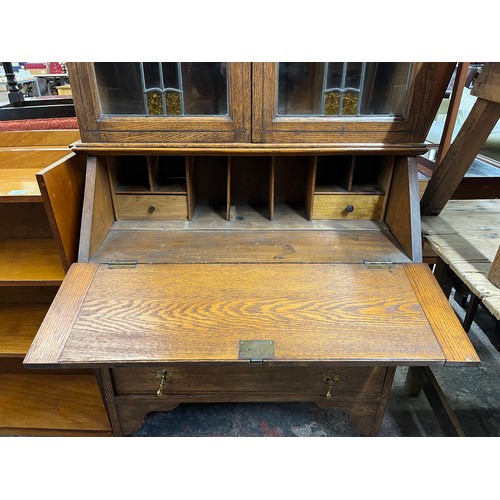 217 - An Arts and Crafts inlaid oak bureau bookcase with two stained and leaded glass doors - approx. 200c... 