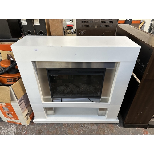 1055 - A Warmlite log burning fire effect electric heater fitted to white laminate surround - approx. 112cm... 