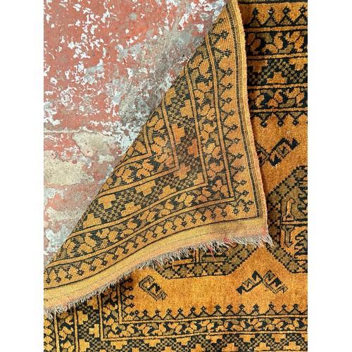 199 - Two mid 20th century burnt orange and black machine woven rugs, one approx. 150cm x 100cm and one ap... 