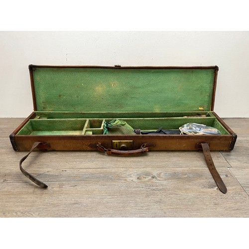 767 - A vintage canvas and leather shotgun case with baize lined interior compartments and oak and brass b... 