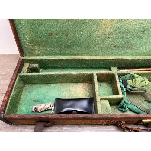 767 - A vintage canvas and leather shotgun case with baize lined interior compartments and oak and brass b... 