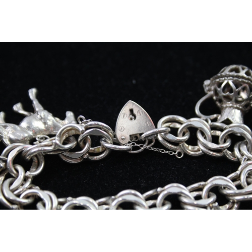 2335 - A silver charm bracelet with novelty charms - approx. gross weight 106g