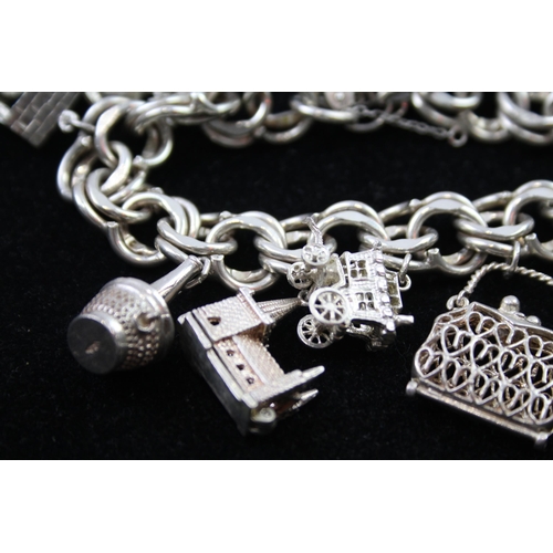 2335 - A silver charm bracelet with novelty charms - approx. gross weight 106g