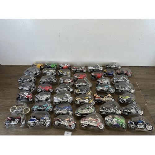 302 - A collection of packaged die-cast model motorcycles to include Harley Davidson, Yamaha, Police, Kawa... 