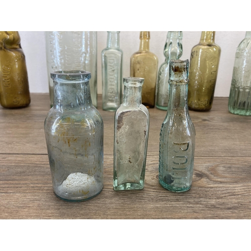 563 - A collection of vintage glass and stoneware bottles to include Parkinson Macclesfield, Thompson Mitc... 