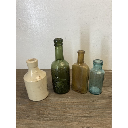 563 - A collection of vintage glass and stoneware bottles to include Parkinson Macclesfield, Thompson Mitc... 