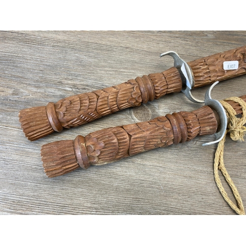 790 - A pair of Middle Eastern decorative tourist swords with carved hardwood handles and sheaths