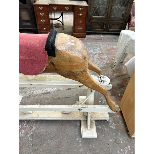 110 - A carved pine rocking horse on white painted stand - approx. 113cm high x 52cm wide x 136cm long