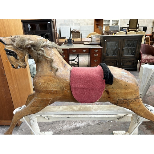 110 - A carved pine rocking horse on white painted stand - approx. 113cm high x 52cm wide x 136cm long