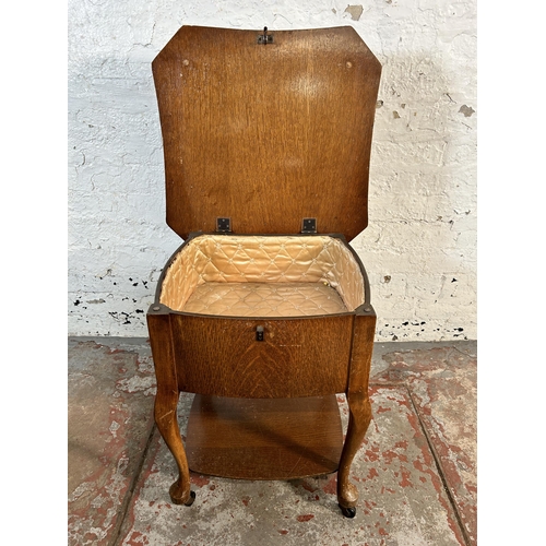 128 - A mid 20th century oak sewing table on cabriole supports