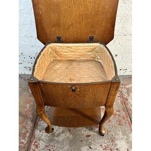 128 - A mid 20th century oak sewing table on cabriole supports