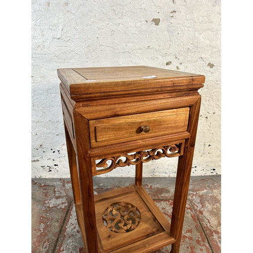 130 - A Chinese carved hardwood two tier side table