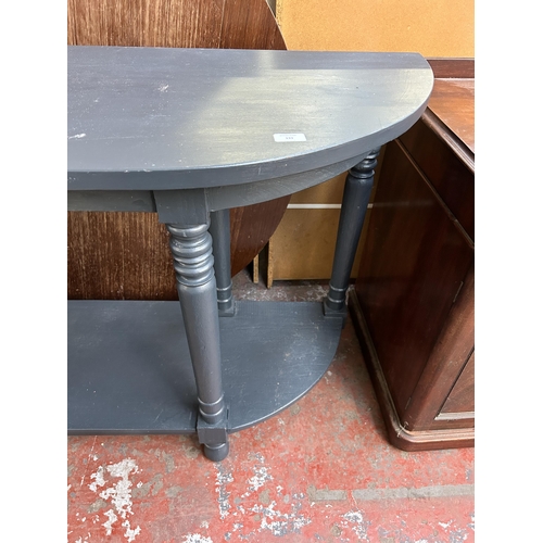 133 - A modern blue painted half moon two tier console table - approx. 85cm high x 180cm wide x 48cm deep