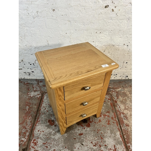 135 - A modern oak bedside chest of drawers - approx. 59cm high x 43cm wide x 35cm deep