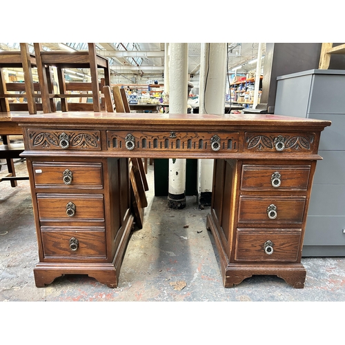 184 - A carved oak and red leather pedestal desk - approx. 80cm high x 128cm wide x 61cm deep