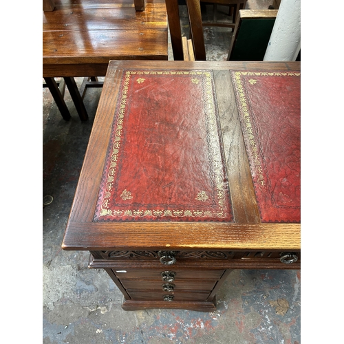 184 - A carved oak and red leather pedestal desk - approx. 80cm high x 128cm wide x 61cm deep