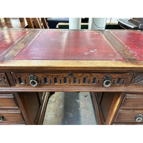 184 - A carved oak and red leather pedestal desk - approx. 80cm high x 128cm wide x 61cm deep