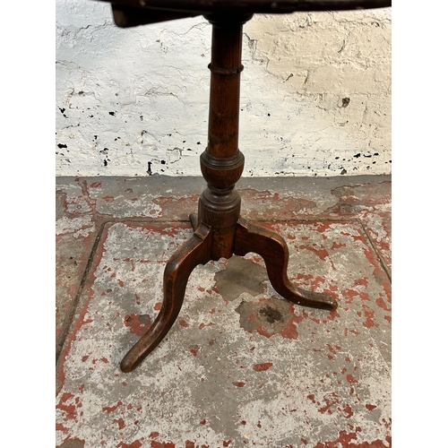 69 - A 19th century oak tilt top tripod side table - approx. 61.5cm high x 47cm diameter