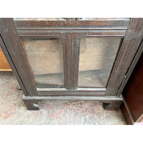 76 - A Georgian oak bookcase with single glazed door on bracket supports - 141cm high x 73cm wide x 31cm ... 