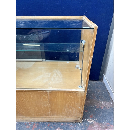 85 - A beech and glass shop display cabinet with two glass sliding doors - approx. 101cm high x 101cm wid... 