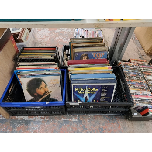 1150 - Twelve boxes containing a large collection of vinyl records, DVDs and one box containing planters