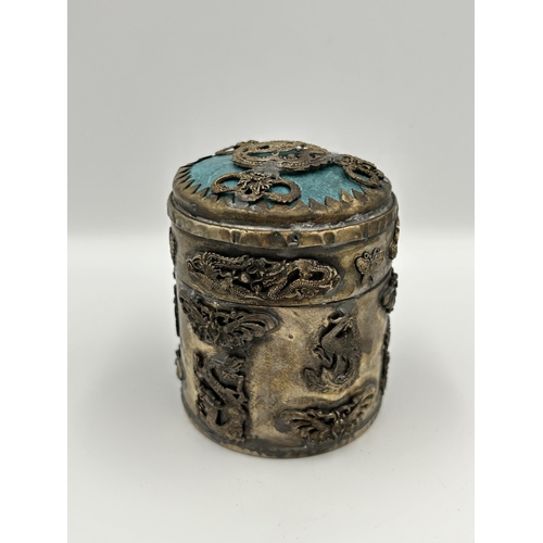 2356 - Three Oriental items, one Tibetan white metal and stone cylindrical lidded box, one Tibetan white me... 