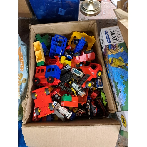 1174 - Three boxes and a bag containing toys and games to include Fortnite Monopoly, jigsaws, Mega Bloks, N... 