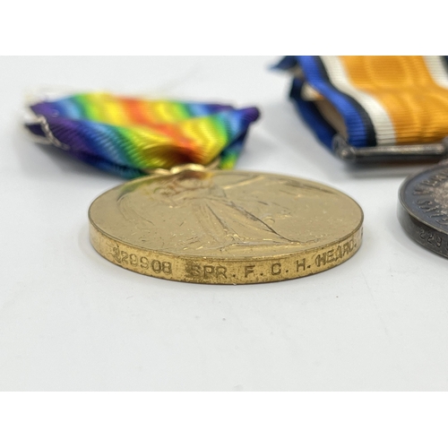 2031 - A boxed WWI British medal pair presented to 229908 Spr. F. C. H. Heard R. E.