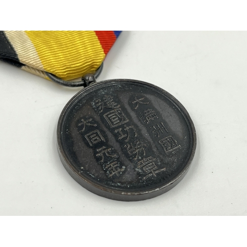 2048 - A boxed Manchukuo National Foundation Merit medal