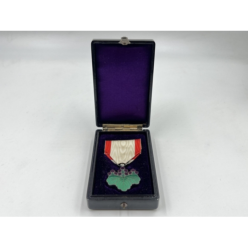 2052 - A boxed Japanese Order of The Rising Sun 7th Class medal