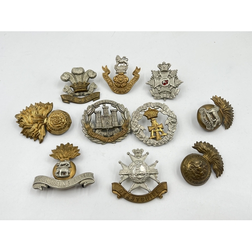 2104 - Ten military cap badges to include The Welsh, Royal Munster, Loyal North Lancashire etc.