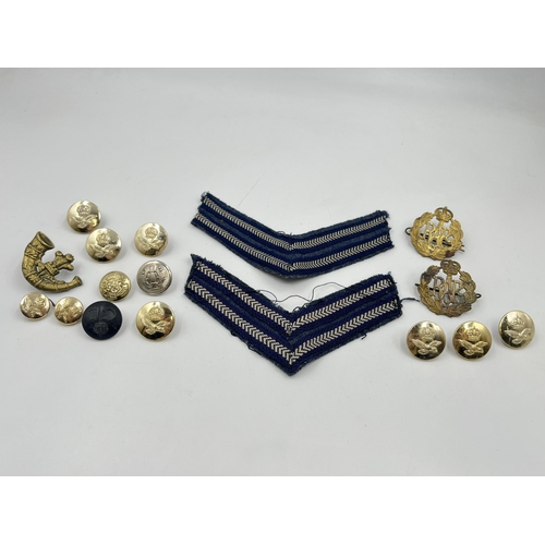 2117 - A collection of military cap badges, buttons and cloth patches to include R.A.F etc.