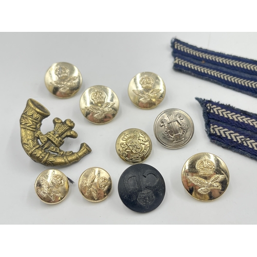 2117 - A collection of military cap badges, buttons and cloth patches to include R.A.F etc.