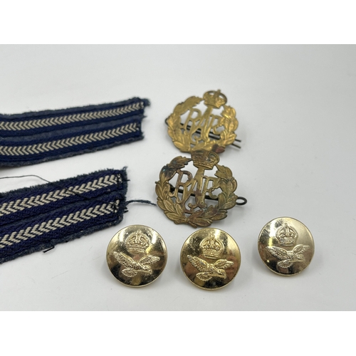 2117 - A collection of military cap badges, buttons and cloth patches to include R.A.F etc.