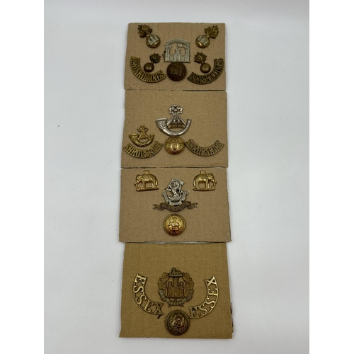 2132 - Twenty military cap badges and buttons to include Essex, Royal Inniskilling Fusiliers etc.