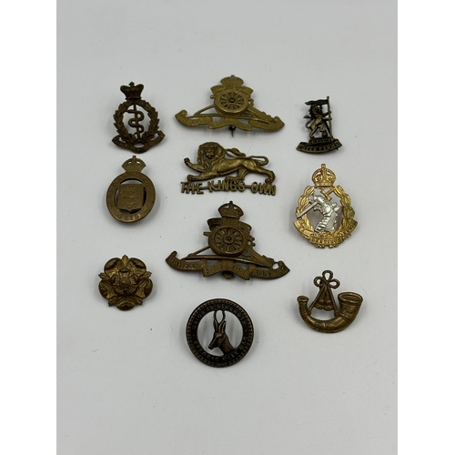 2142 - A collection of military cap badges