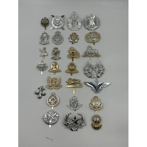 2144 - A collection of military cap badges