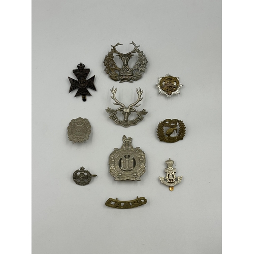 2156 - A collection of military cap badges