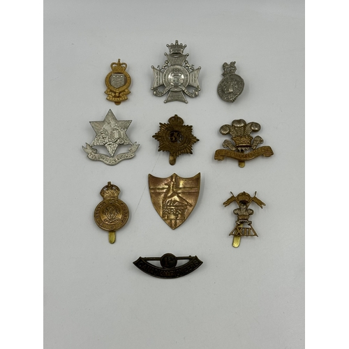 2160 - A collection of military cap badges