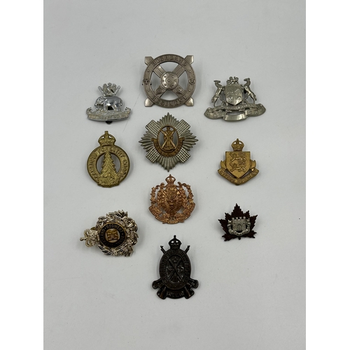 2161 - A collection of military cap badges