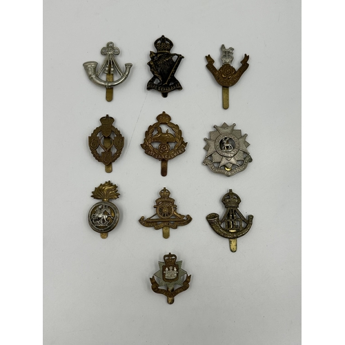 2162 - A collection of military cap badges