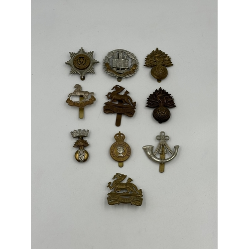 2164 - A collection of military cap badges