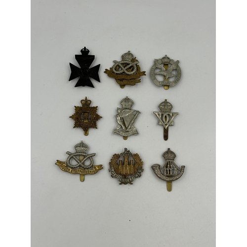 2165 - A collection of military cap badges