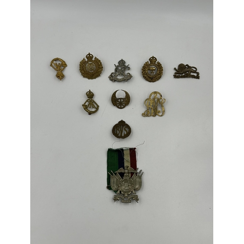 2167 - A collection of military cap badges