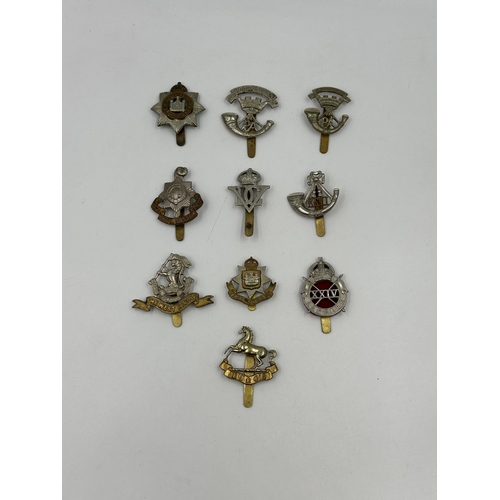 2173 - A collection of military cap badges