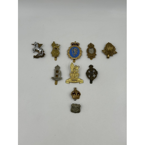 2180 - A collection of military cap badges