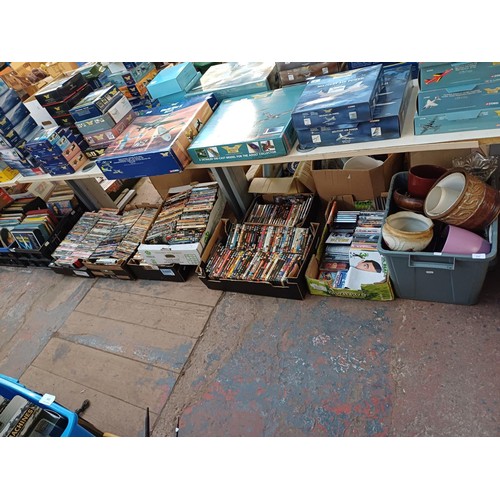 1150 - Twelve boxes containing a large collection of vinyl records, DVDs and one box containing planters