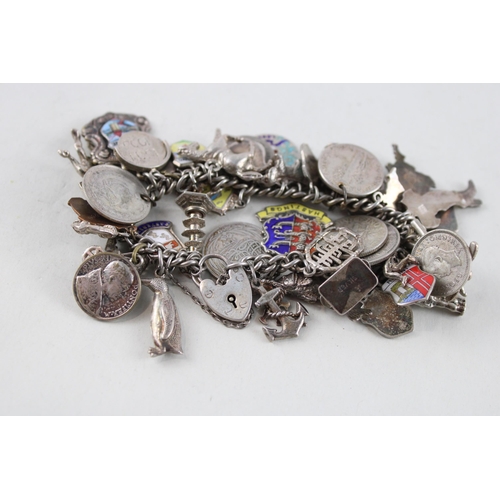 2039 - A silver charm bracelet with assorted charms - approx. gross weight 93g