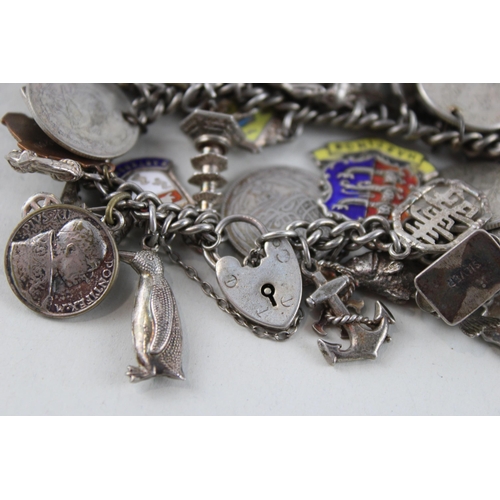 2039 - A silver charm bracelet with assorted charms - approx. gross weight 93g