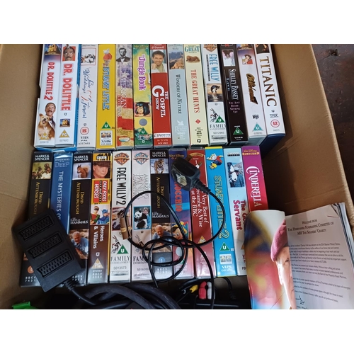 627 - Three boxes containing books, CDs, DVDs, VHS videos, Sony VHS VCR with remote control, Panasonic DVD... 